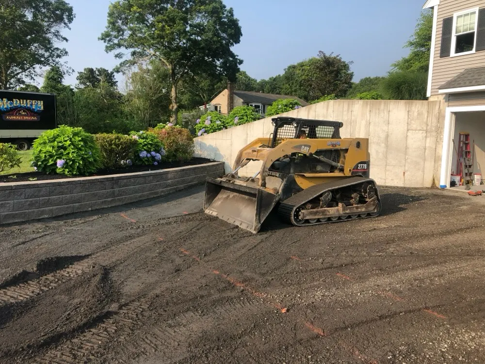 Skid steer grading a driveway base