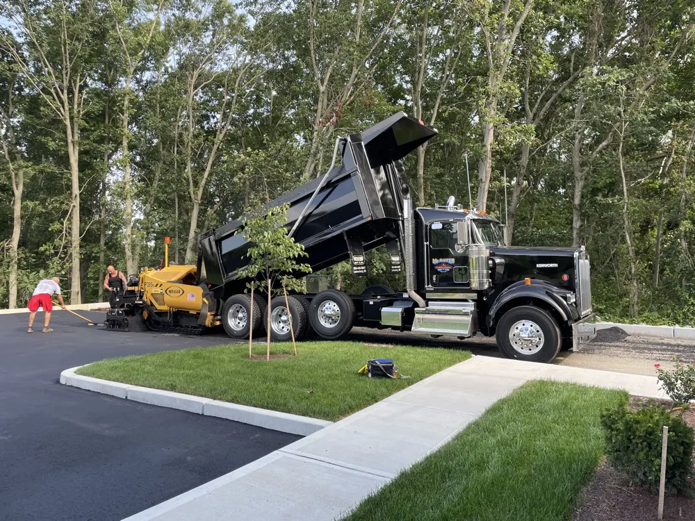 Dump truck and paver finishing a new parking area