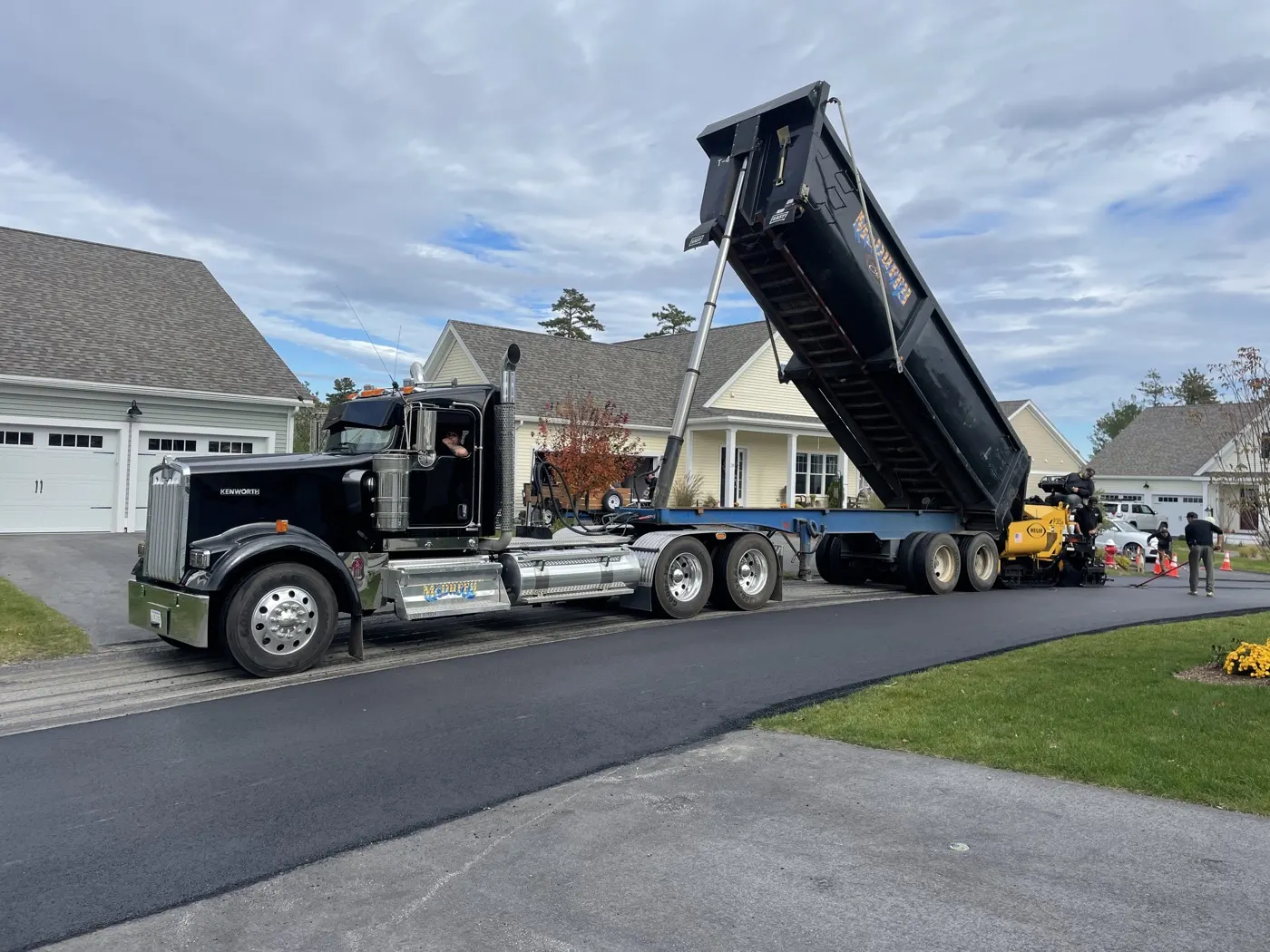 McDuffy & Son dump truck feeding the paver on a freshly paved driveway